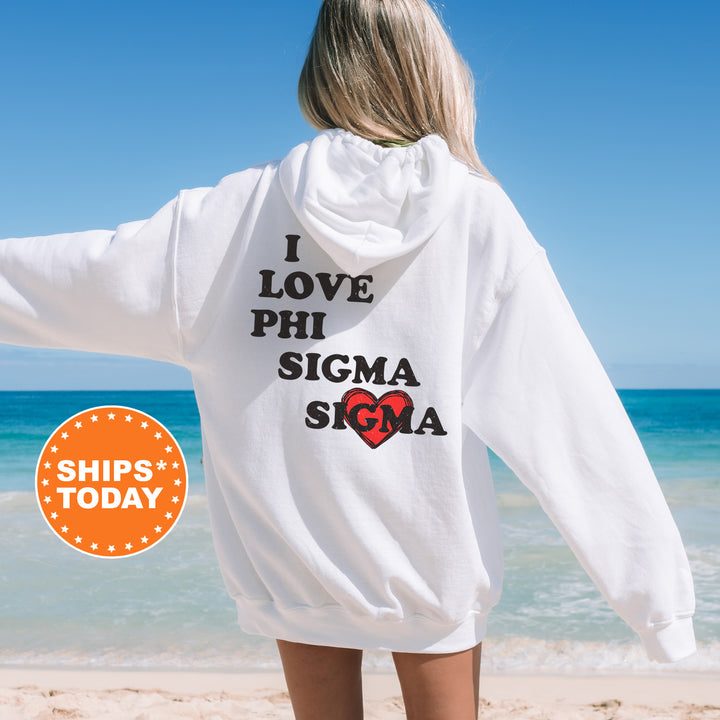 a woman standing on a beach wearing a white sweatshirt