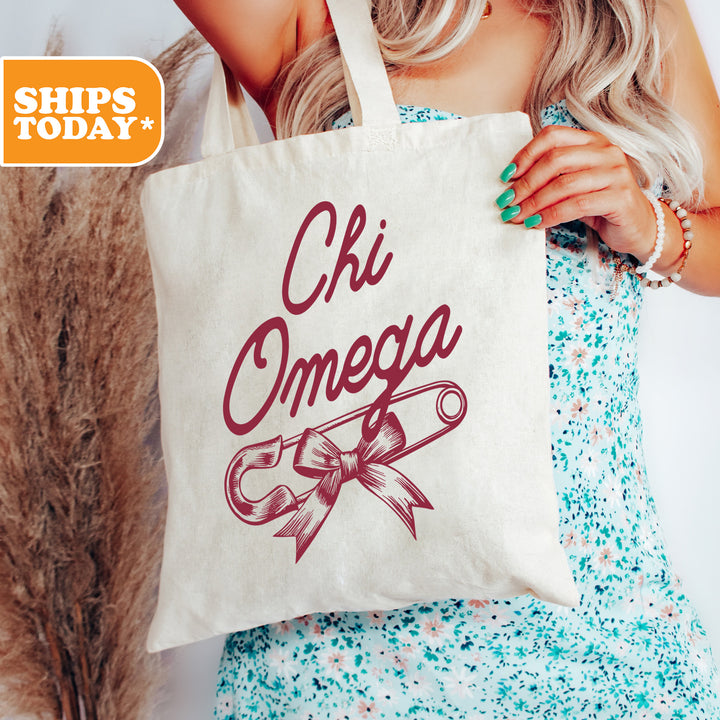a woman holding a tote bag that says chi omega