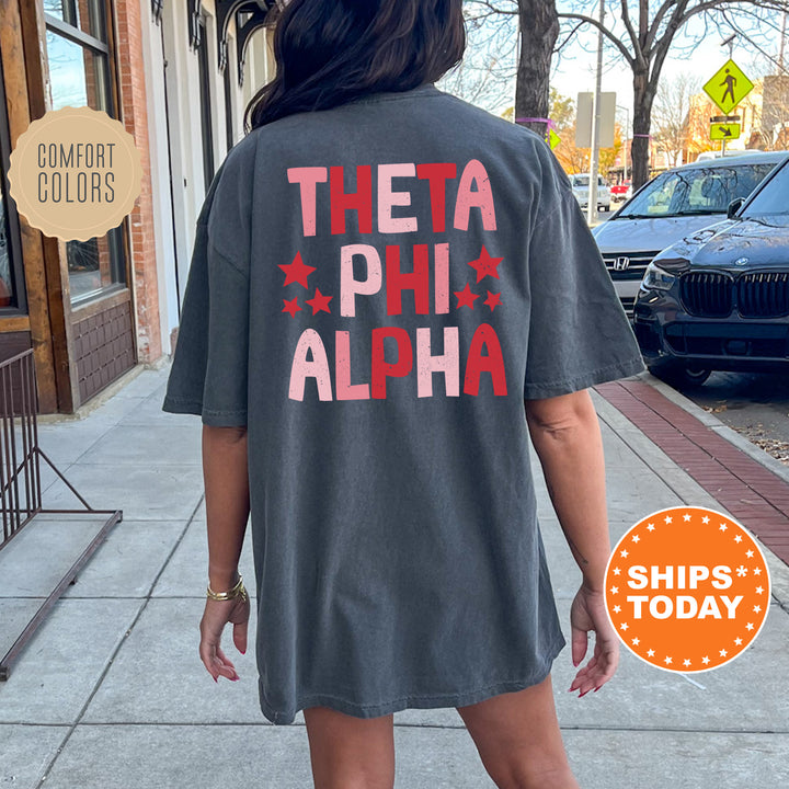 a woman walking down a sidewalk wearing a shirt that says thea phih al