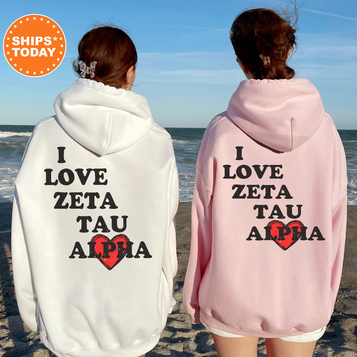 two women wearing matching sweatshirts on the beach