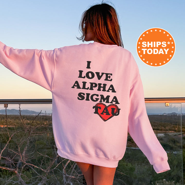 a woman wearing a pink sweatshirt that says i love alpha sigma
