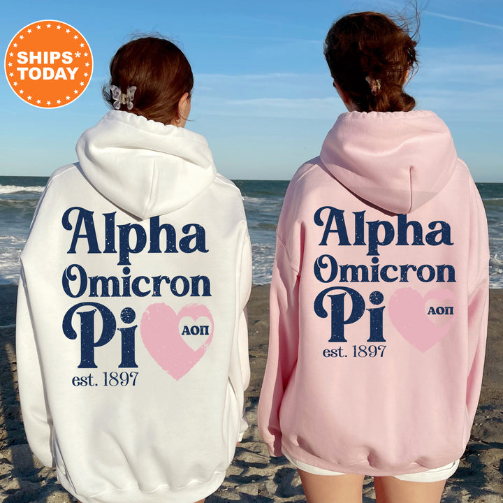 two women in matching pink and white hoodies on the beach