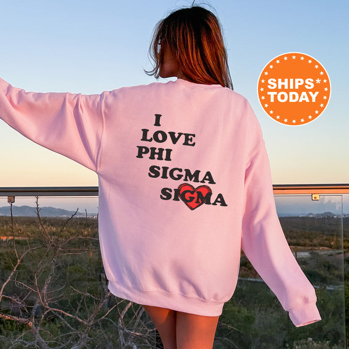 a woman wearing a pink sweatshirt with the words i love phi sigma on