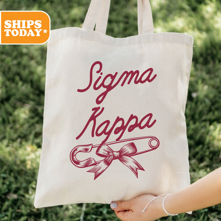 a person holding a tote bag with a ribbon on it