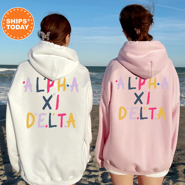 two girls wearing pink and white sweatshirts on the beach
