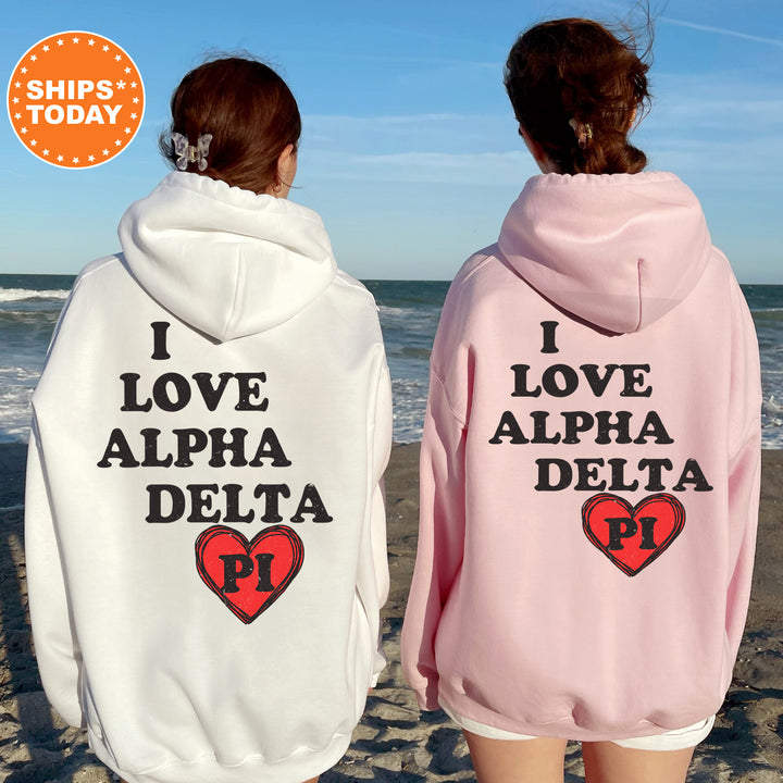 two women wearing pink and white sweatshirts on the beach