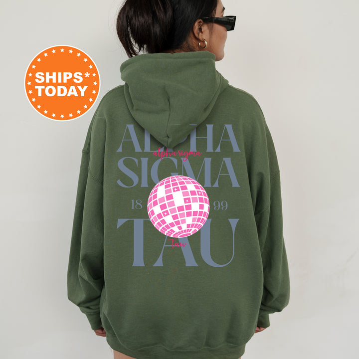 a woman wearing a green hoodie with a pink globe on it