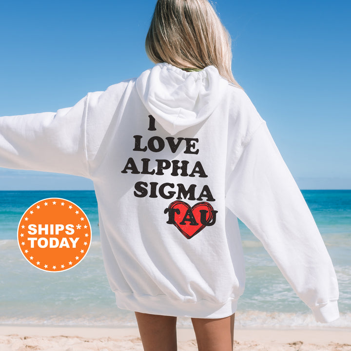 a woman standing on a beach wearing a white sweatshirt
