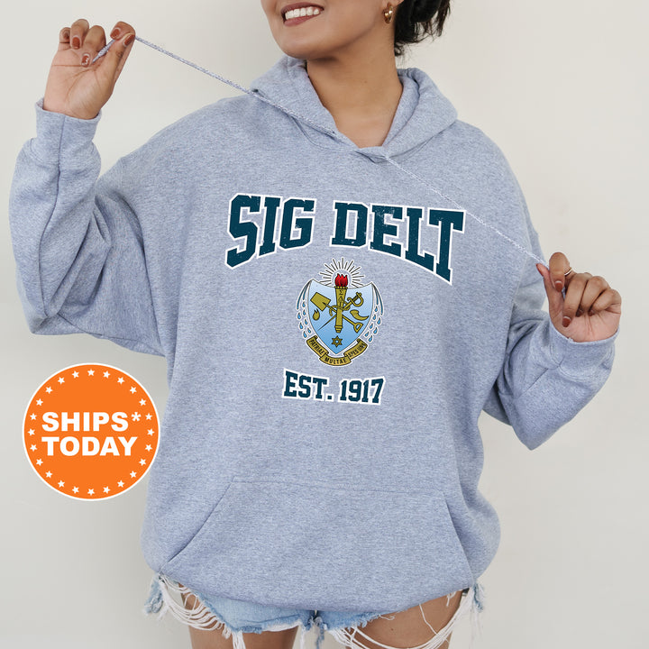 a woman wearing a blue sweatshirt with a crest on it