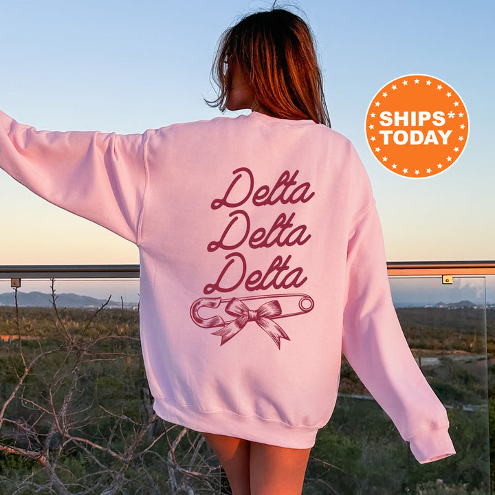 a woman wearing a pink sweatshirt with the words delta delta written on it