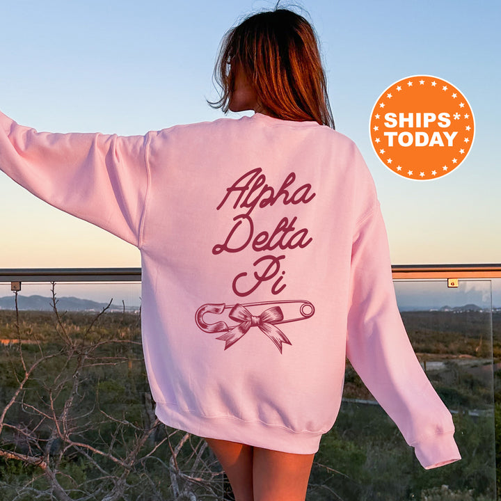 a woman wearing a pink sweatshirt with the words apara delta pi on it
