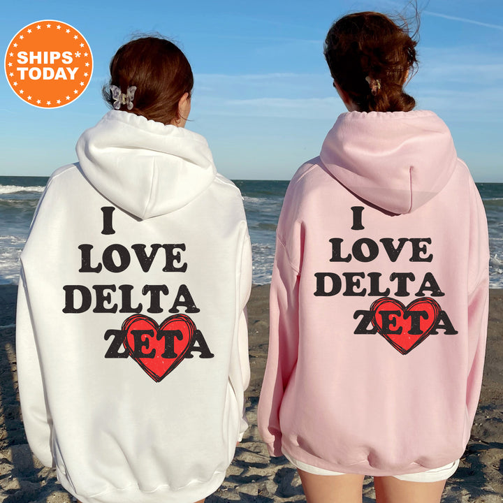 two women wearing matching sweatshirts on the beach