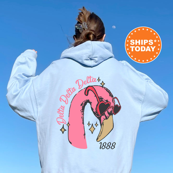 a woman wearing a white sweatshirt with a pink flamingo on it