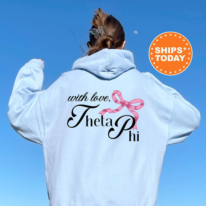 a woman wearing a white hoodie with a pink bow on it