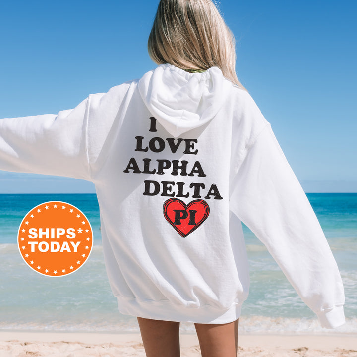 a woman standing on a beach wearing a white hoodie