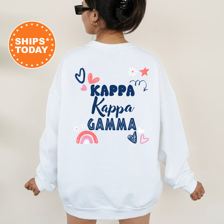 a woman wearing a white sweatshirt with the words kapp kapa gama on
