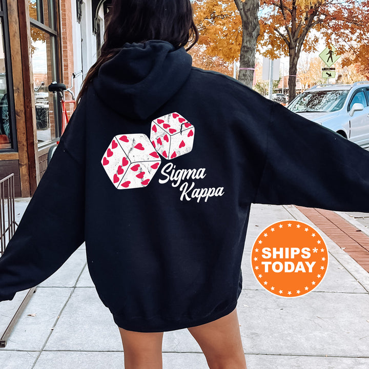 a woman walking down a sidewalk wearing a black hoodie