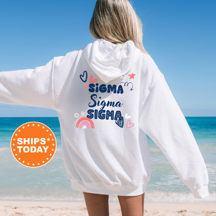 a woman standing on a beach wearing a white sweatshirt