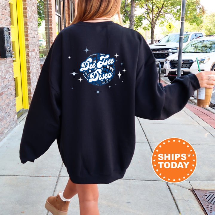 A person wearing a black sweatshirt with a graphic design on the back is walking down a sidewalk.