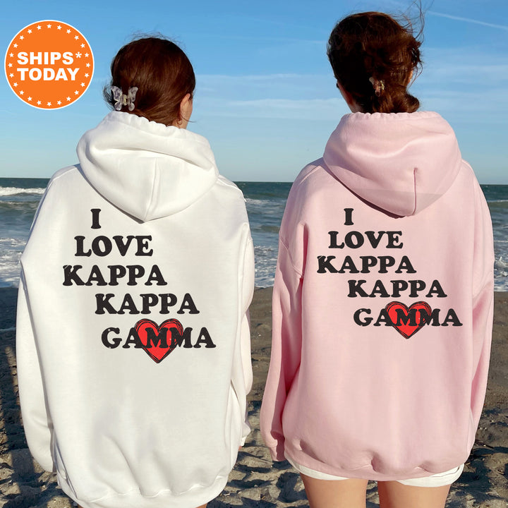 two women wearing pink and white hoodies on the beach