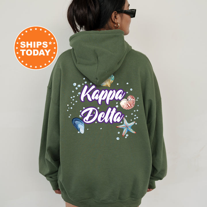 a woman wearing a green hoodie with the words kapa pela on it