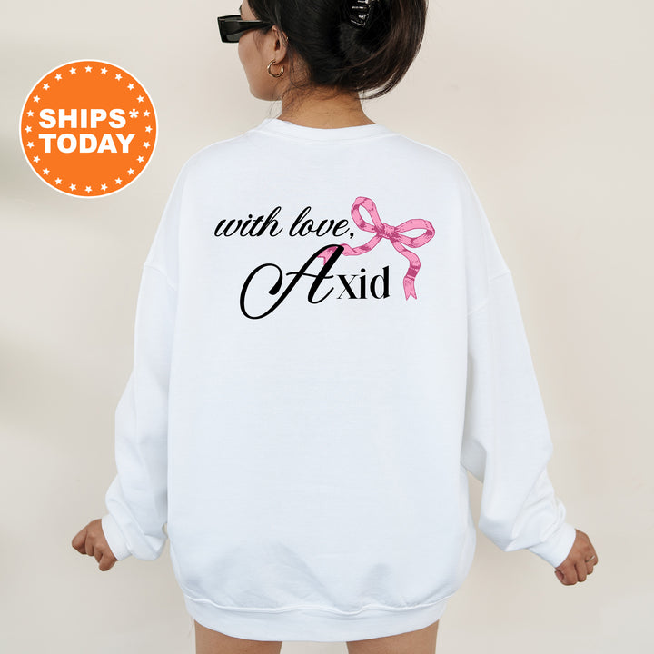 a woman wearing a white sweatshirt with a pink ribbon on it