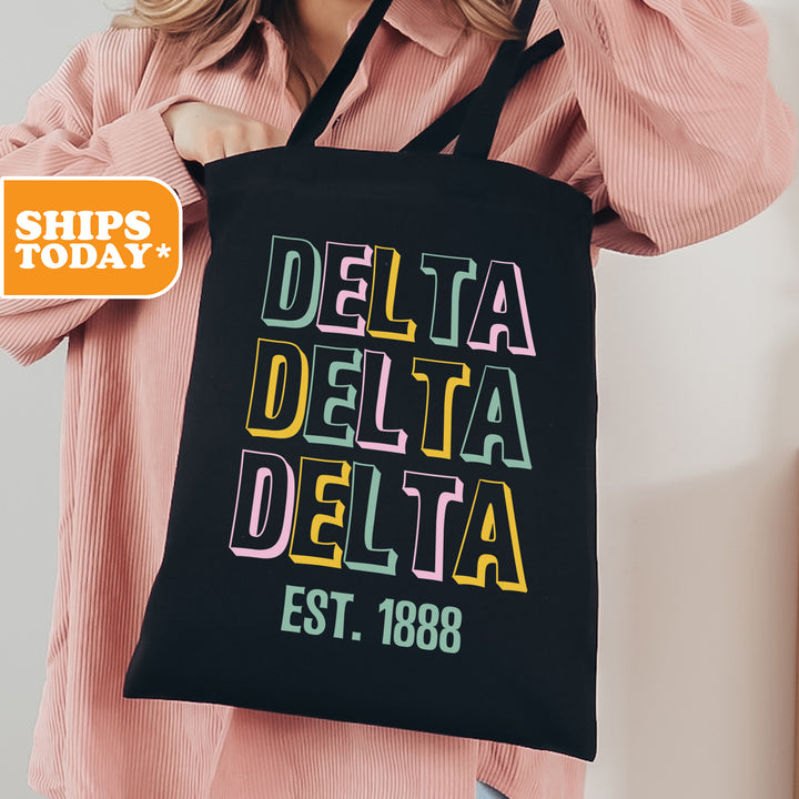 a woman holding a black bag with the words delta delta on it
