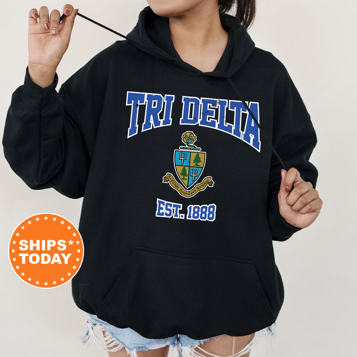 a woman wearing a black hoodie with a crest on it