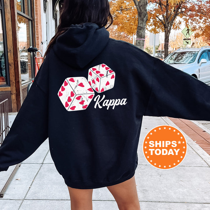 a woman walking down a sidewalk wearing a black hoodie