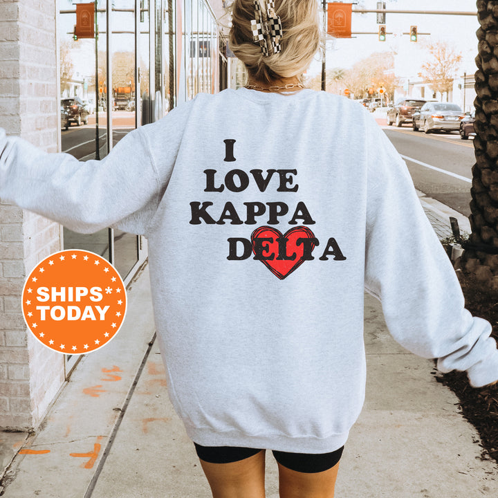 a woman walking down a sidewalk wearing a sweatshirt that says i love kapa de