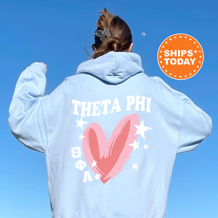 a woman wearing a blue hoodie with a pink heart on it