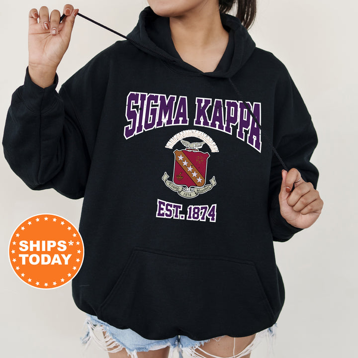 a woman wearing a black hoodie with a crest on it