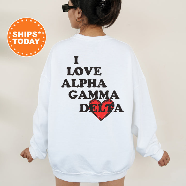 a woman wearing a white sweatshirt with the words i love alpha gama de