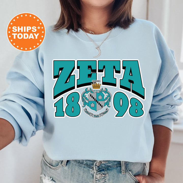 a woman wearing a blue sweatshirt with the word zeta on it