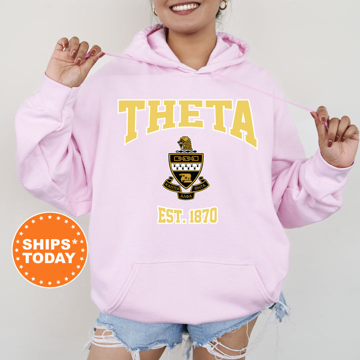 a woman wearing a pink hoodie with the words theta on it
