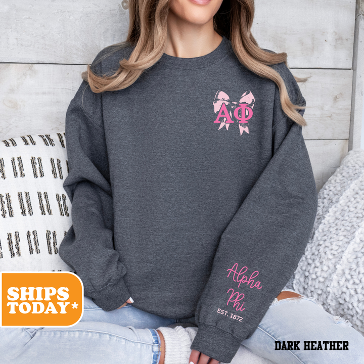 a woman sitting on a bed wearing a gray sweatshirt