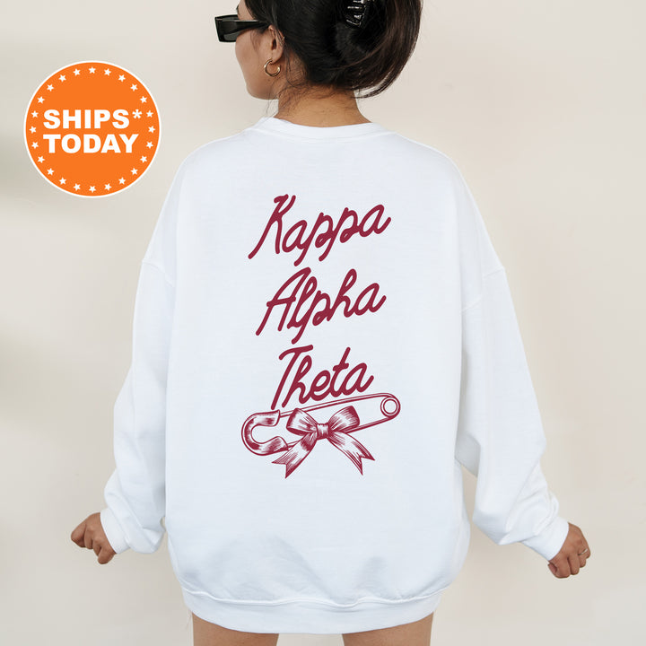 a woman wearing a white sweatshirt with a red ribbon on it
