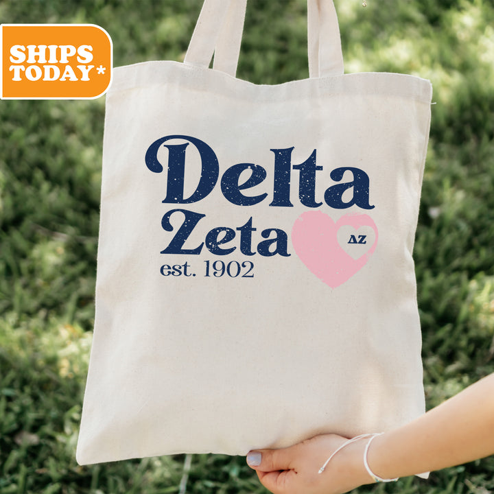 a person holding a tote bag with delta zeia on it