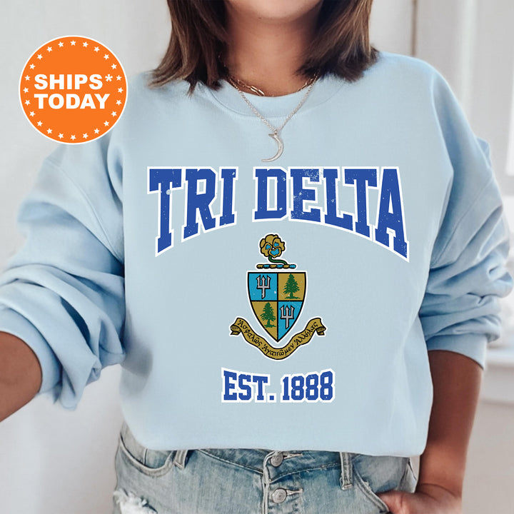 a woman wearing a blue sweatshirt with the words tri delta on it