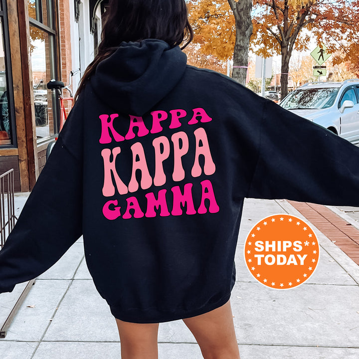 a woman wearing a black hoodie with pink letters on it