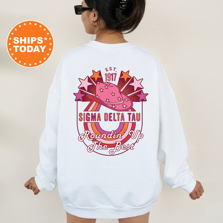 a woman wearing a white sweatshirt with a pink hat on it