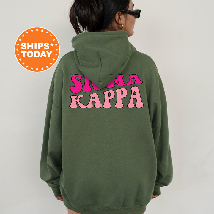 a woman wearing a green hoodie with pink letters on it