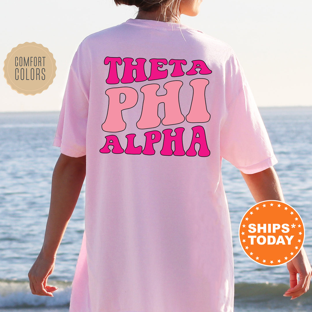 a woman wearing a pink shirt that says, thea phi alpha