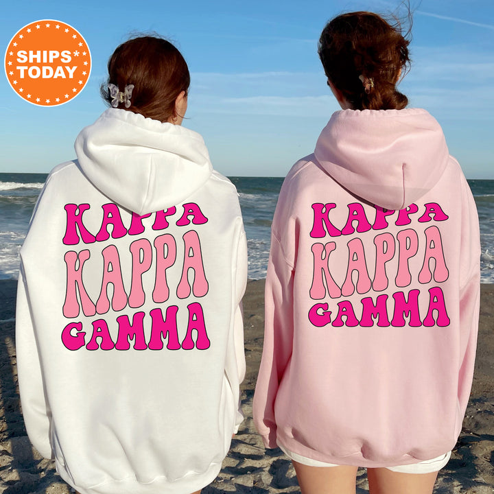 two women wearing pink and white sweatshirts on the beach