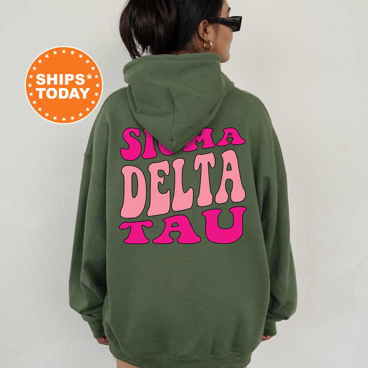 a woman wearing a green sweatshirt with pink letters on it