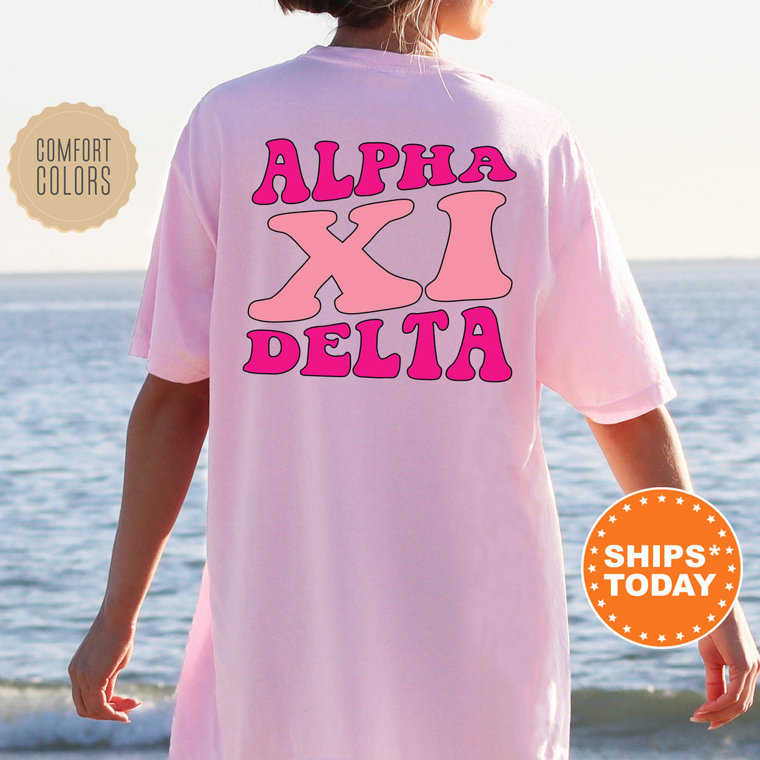 a woman wearing a pink shirt that says,'alpha x'delta '