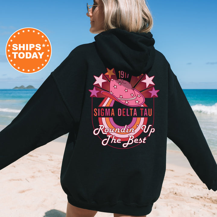 a woman in a black hoodie on the beach
