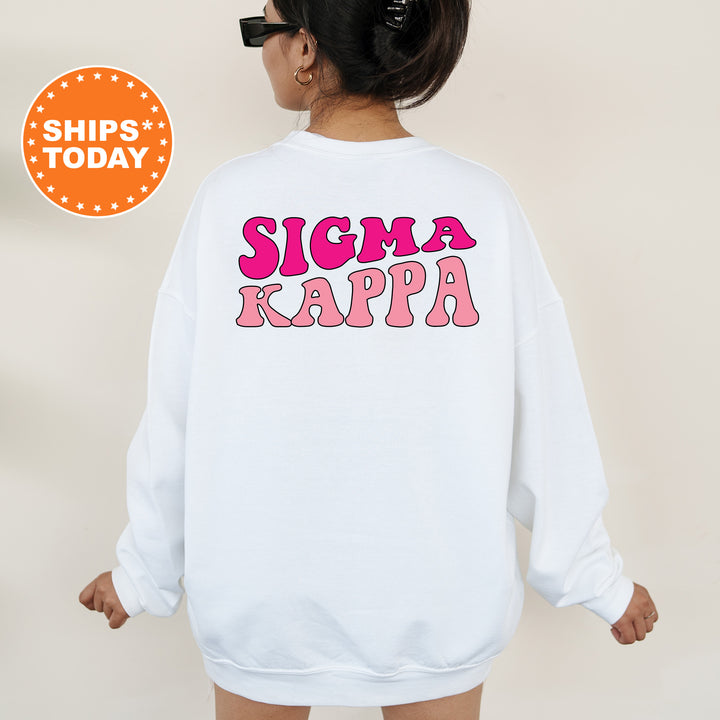 a woman wearing a white sweatshirt that says stigmaa kappa