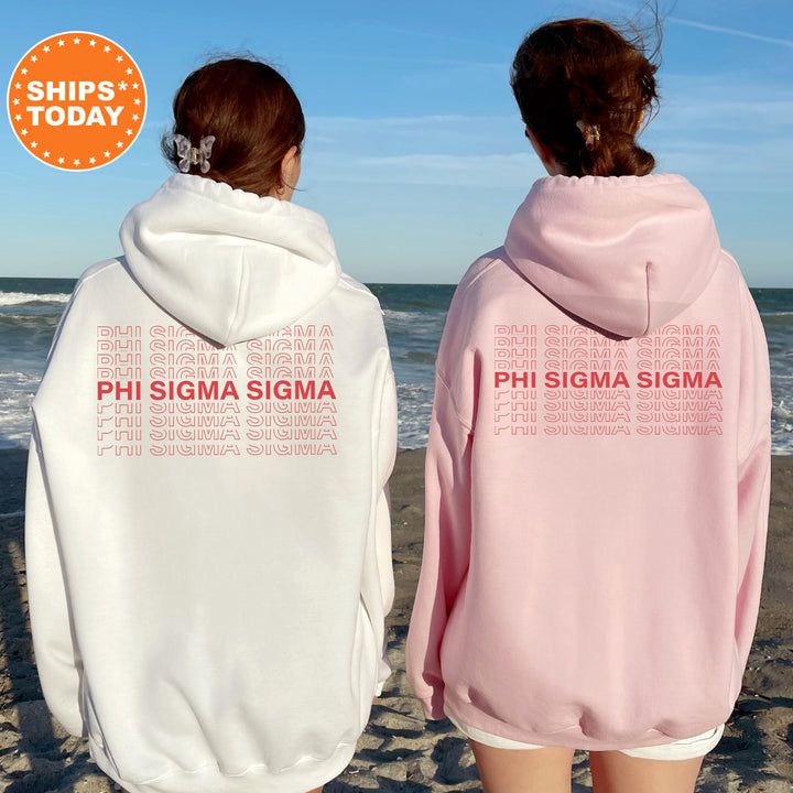 two women wearing pink and white sweatshirts on the beach