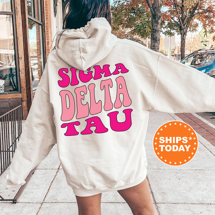 a woman walking down a sidewalk wearing a white hoodie